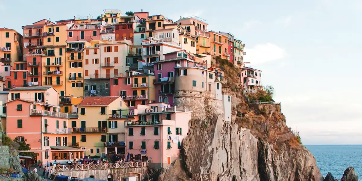 Pueblo costero de casas de colores sobre un acantilado al atardecer