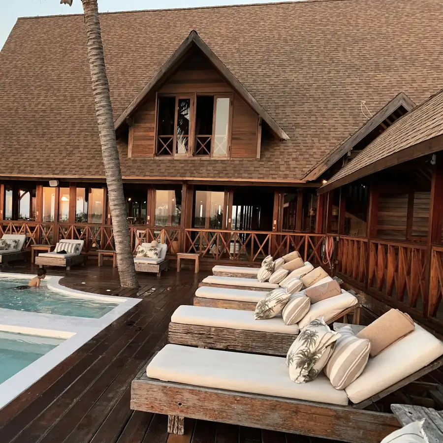 Terraza de un alojamiento boutique junto a la piscina al atardecer