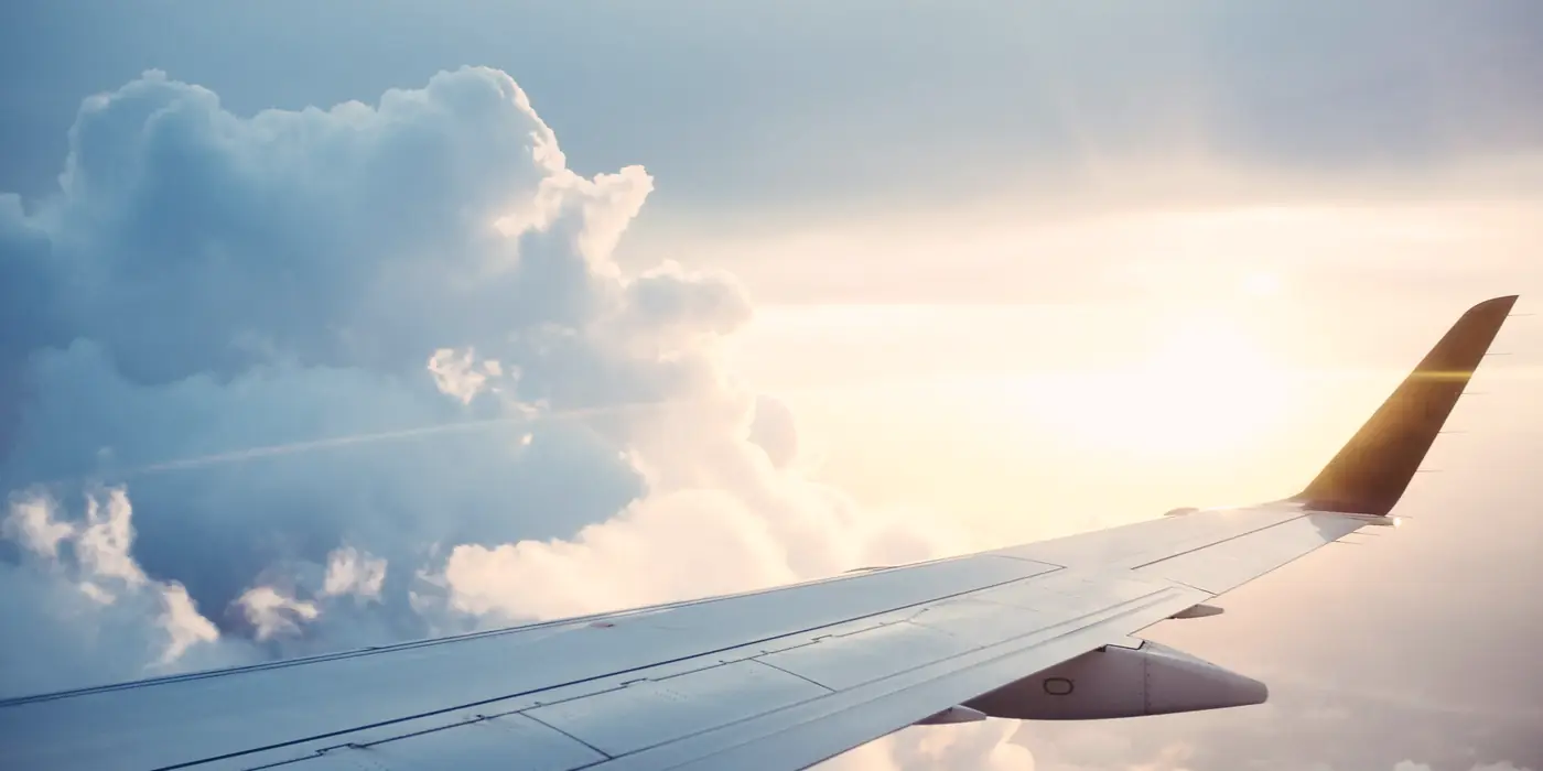 Ala de un avión sobre un mar de nubes al amanecer